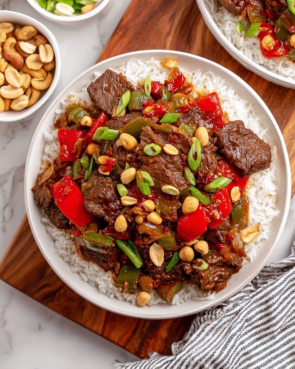 The dish is presented in a white bowl filled with a base layer of white rice, topped with a colorful mixture of stir-fried ingredients. The second layer consists of browned pieces of beef with a slightly glossy texture, mixed with chunks of red and green bell peppers and pieces of cooked onions, all coated with a savory sauce. Scattered throughout are small, shiny roasted peanuts and thin green rings of chopped green onions that add color contrast. The bowl sits on a white marbled surface with a wooden board partially visible beneath it. Nearby are additional white bowls with nuts and other ingredients, and a striped cloth is placed at the bottom left corner of the frame. photo taken with an iphone --ar 4:5 --v 7