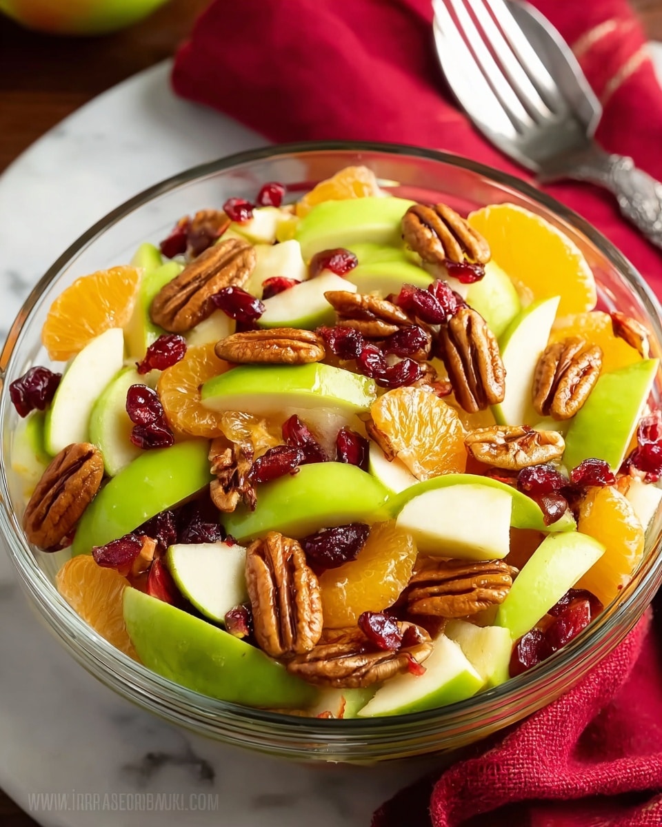 A clear glass bowl filled with a colorful fruit salad sits on a white marbled surface with a red cloth and two silver forks nearby. The salad has three main layers of mixed fruit and nuts. The bottom layer has bright green apple slices with smooth skin, cut into thick wedges. The middle layer contains juicy orange mandarin segments, slightly translucent and round. The top layer is scattered with dark red dried cranberries and whole pecan nuts, adding a rough and textured look. The mix looks fresh and vibrant, with the shiny fruits and nuts contrasting well inside the clear bowl. Photo taken with an iphone --ar 4:5 --v 7