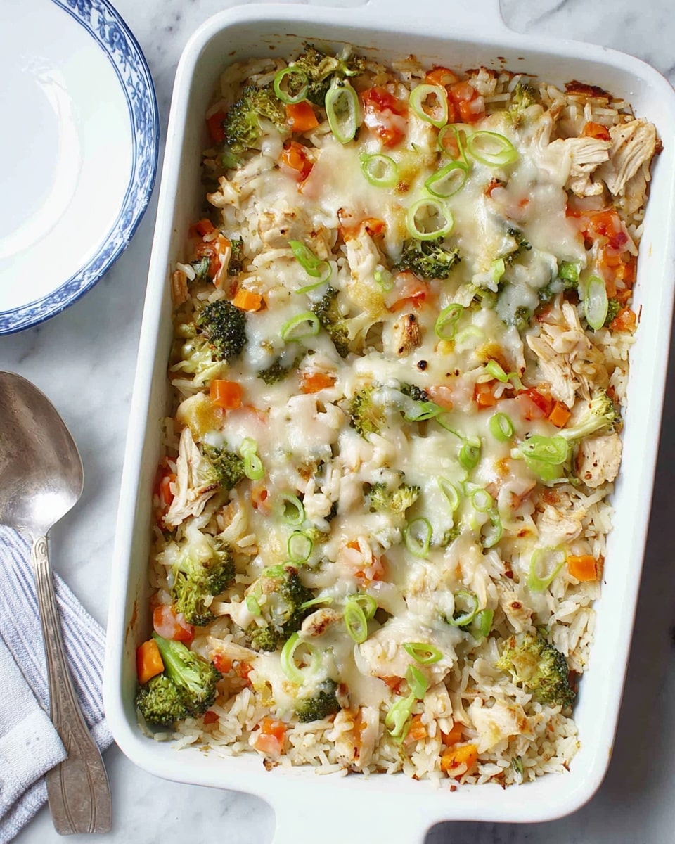 A white rectangular baking dish filled with a baked casserole showing three main layers: the bottom layer is mixed shredded chicken with small bits of red bell pepper and chopped broccoli, the middle layer is a melted white cheese layer spread unevenly, and the top layer has more shredded chicken scattered with finely chopped green onions and additional red bell pepper pieces, giving a colorful and textured look. The dish rests on a white marbled surface with a white and blue striped cloth nearby, and to the side, there is a white plate with a blue rim holding two silver forks along with a silver spoon placed next to the dish. Photo taken with an iphone --ar 4:5 --v 7