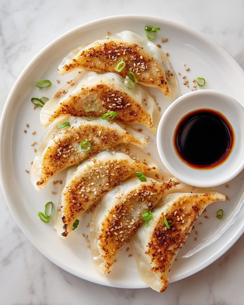 A white plate holds a circle of six golden brown pan-fried dumplings, each with a crispy, slightly charred top layer sprinkled with toasted sesame seeds and small green onion pieces; the dumplings have a soft, translucent dough showing a light, creamy color underneath the crisp layer, forming a half-moon shape with crimped edges. At the top left edge of the plate, there is a small white bowl filled with dark soy sauce. The background is a white marbled texture. photo taken with an iphone --ar 4:5 --v 7